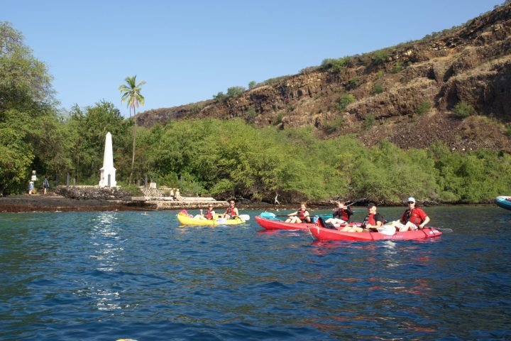 a group of people rowing a boat in a body of water